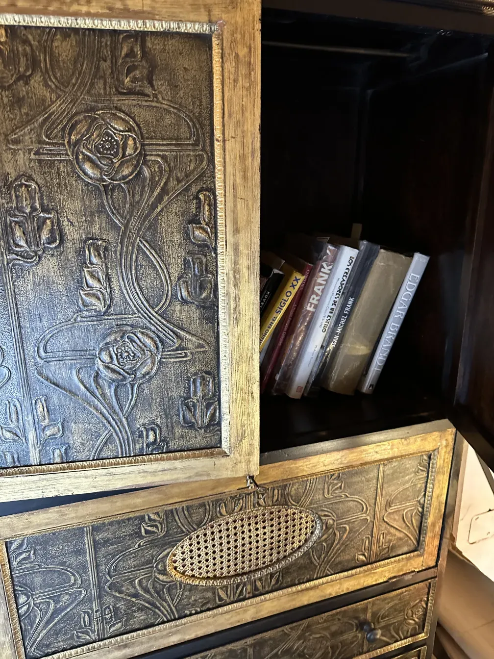 Bar antigo com decoração dourada e livros dentro.