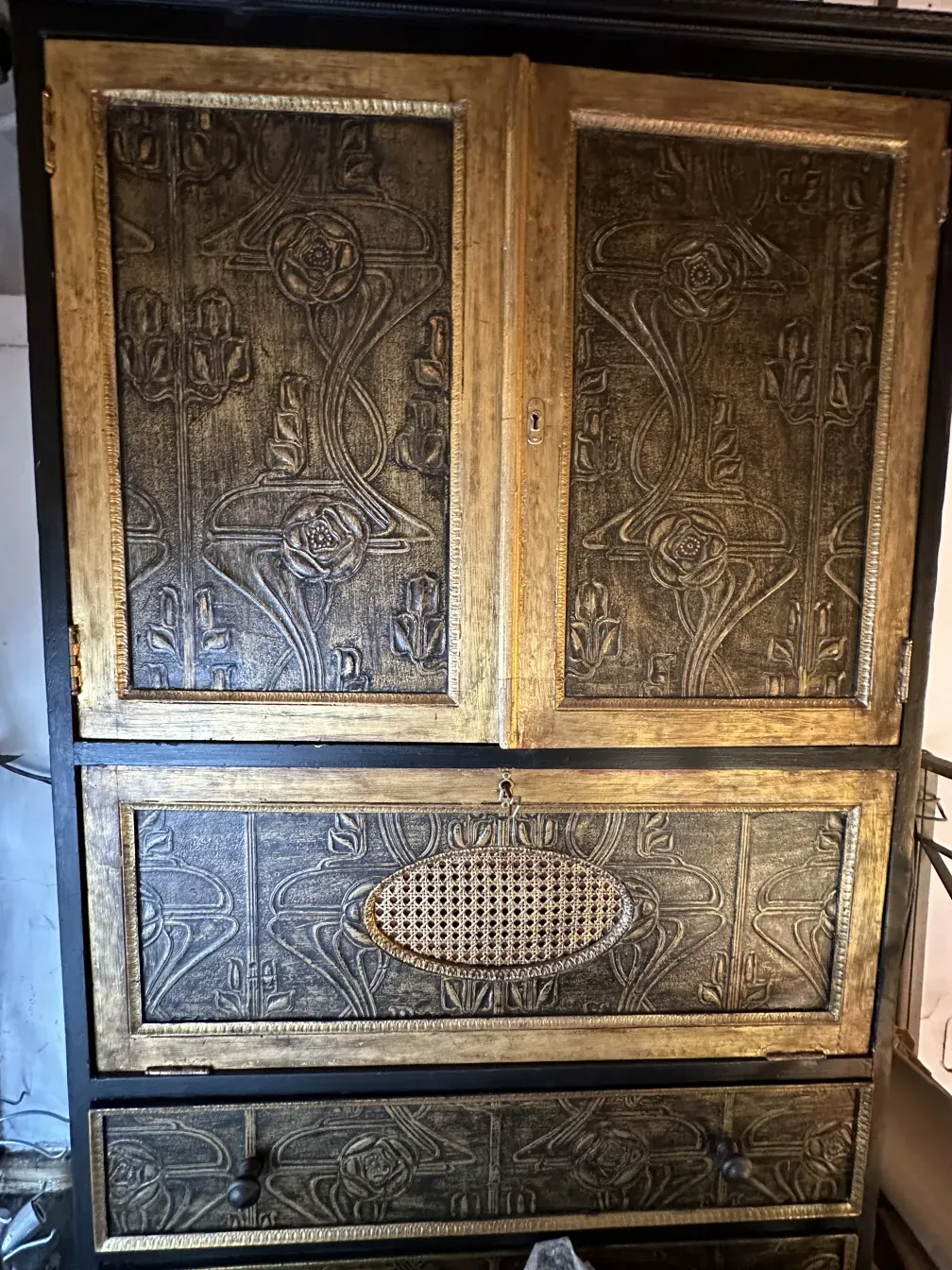 Bar aparador antigo com detalhes em relevo dourados e pretos.