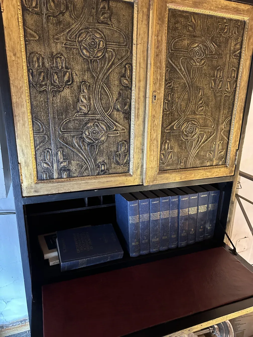 Antique bar with intricate design and books inside