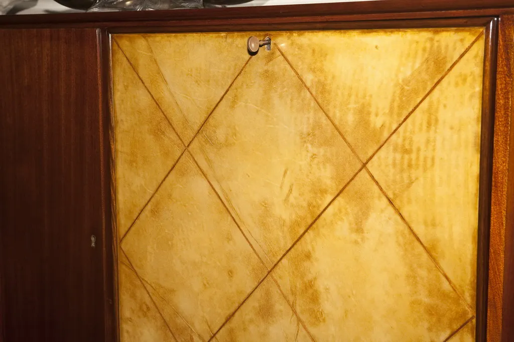 Detailed view of an antique bookcase with art deco finishes. Predominantly golden color adds an elegant touch.