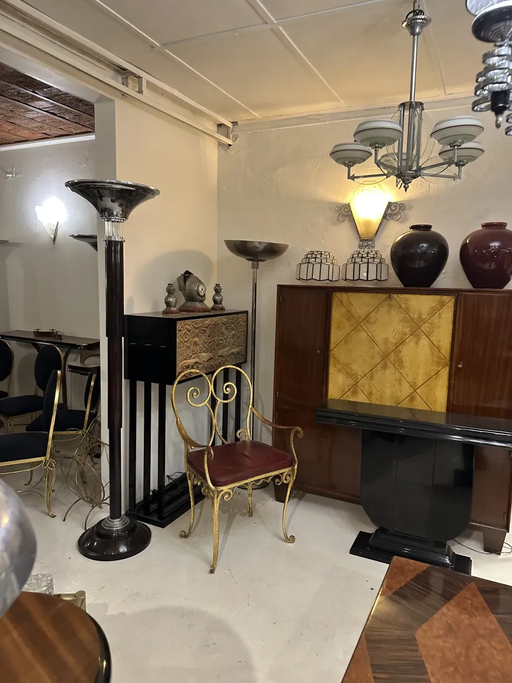 पुराना आर्ट डेको किताबों की अलमारी शानदार सजावट के साथ, सजावटी वस्तुओं से घिरी हुई।