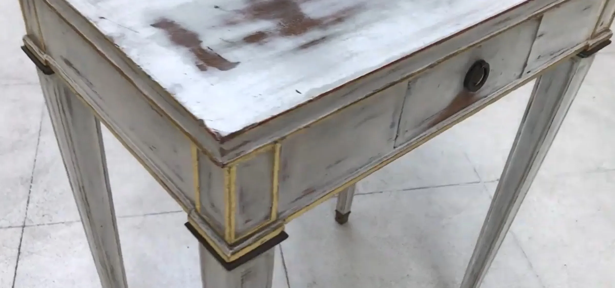Antique white desk with gold details, elegant and refined.