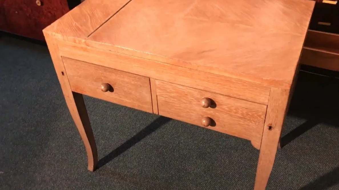 Античный деревянный стол с двумя закругленными ящиками в уютной обстановке.