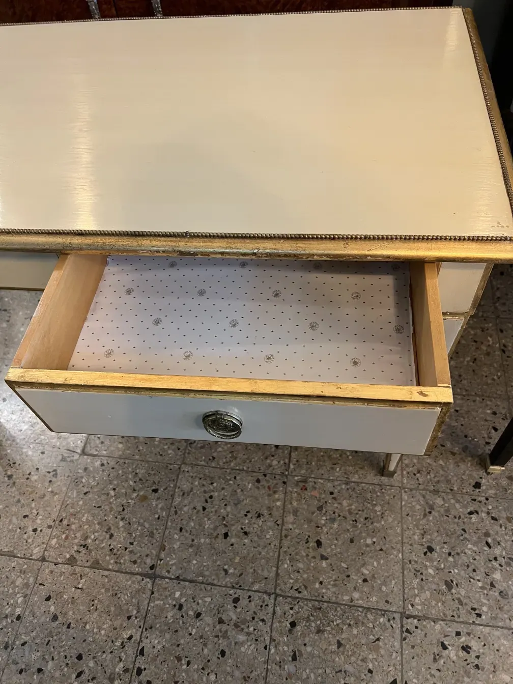 escritorio antigo com uma gaveta branca e detalhes dourados