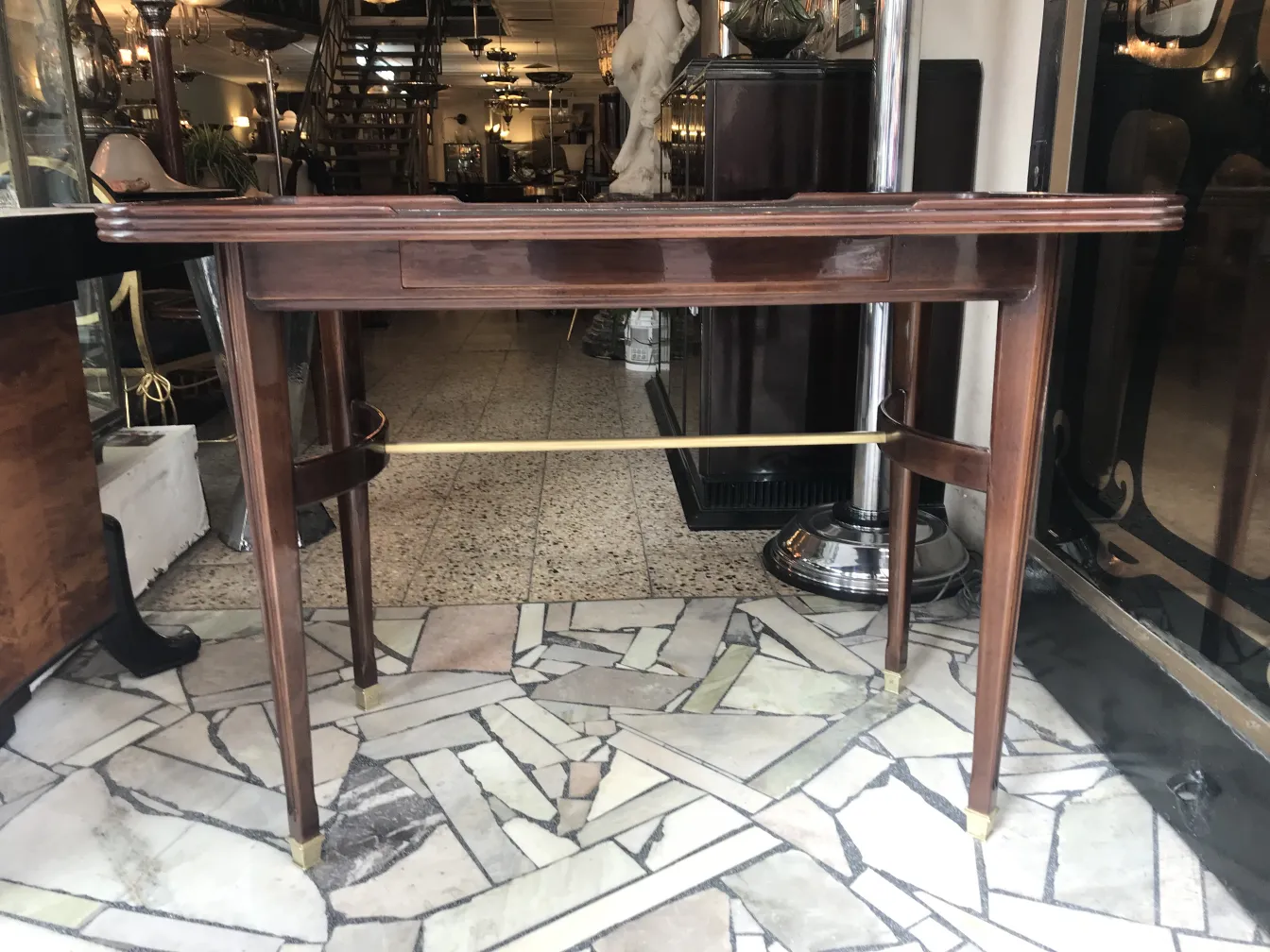 console ancienne avec des jambes élégantes et un design distinctif, dans un cadre sophistiqué