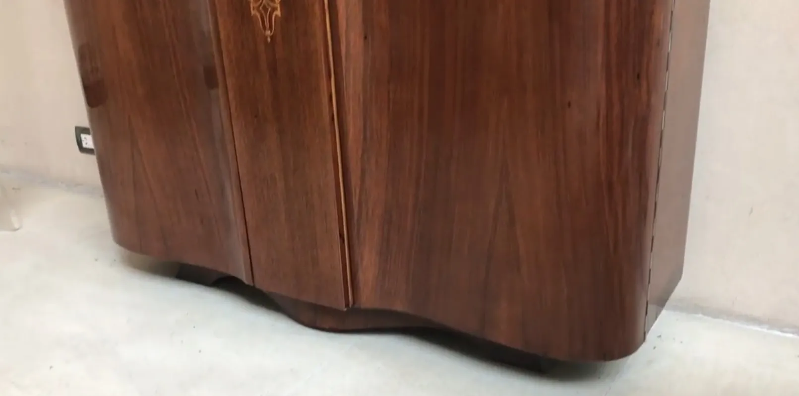 Visão de uma antiga estante de livros com detalhes decorativos, fundo neutro.