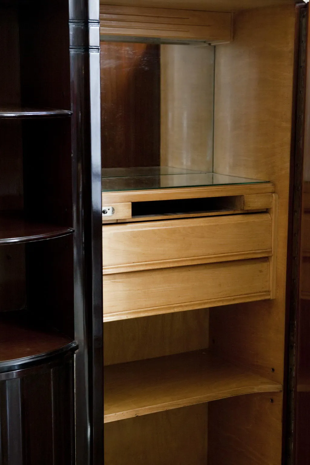 Antique bookcase with shelves and a drawer, dark background.