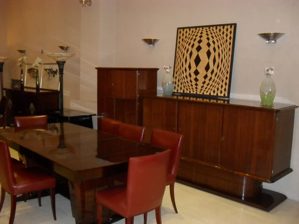 Antique bookcase with an elegant design and cozy atmosphere, surrounded by chairs and decorations.
