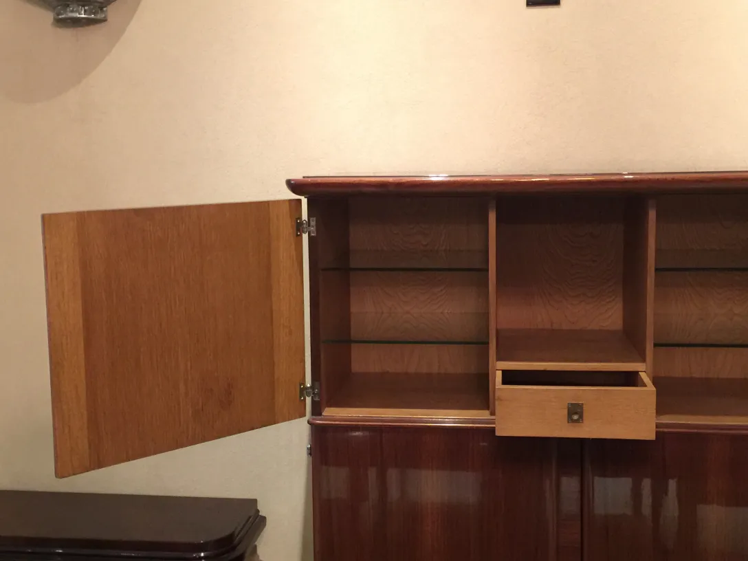 Libreria antica con scaffali e un piccolo cassetto.