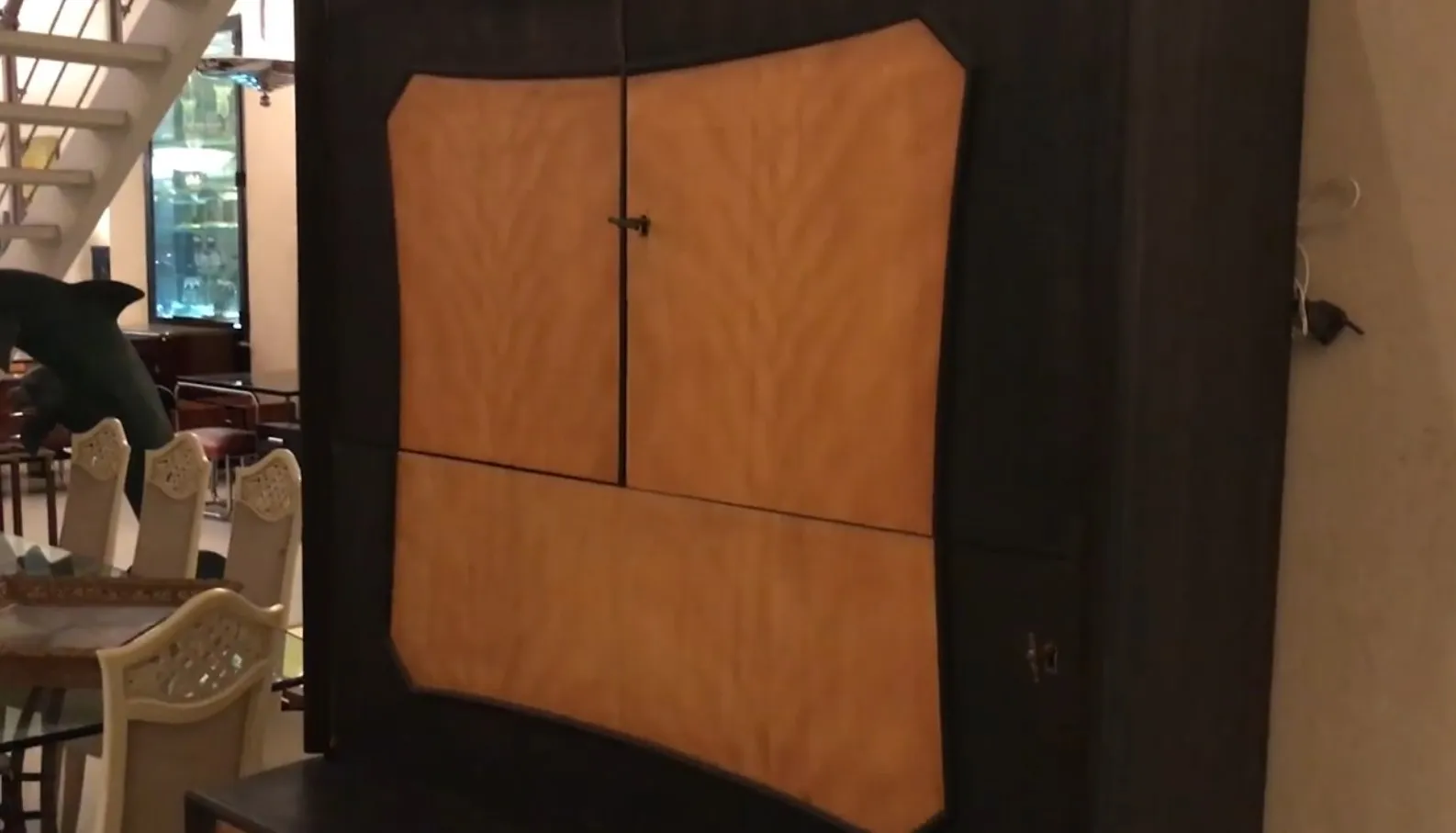 Antiker Bar mit elegantem Design, glatter Oberfläche, in einer gemütlichen Umgebung mit Stühlen und einem Fisch im Hintergrund.