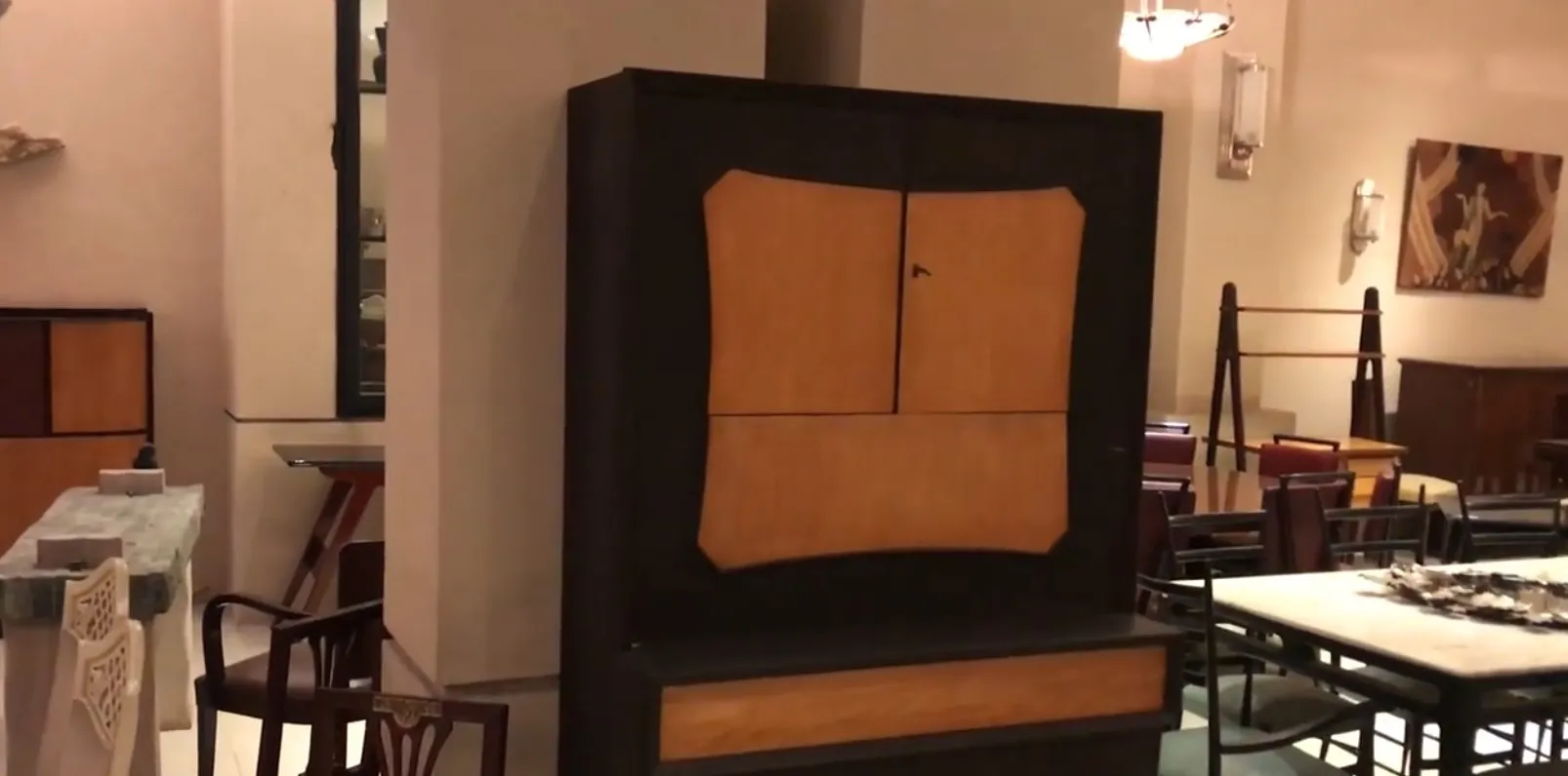 따뜻한 색상의 고풍스러운 칵테일 캐비닛, 가구로 둘러싸인.