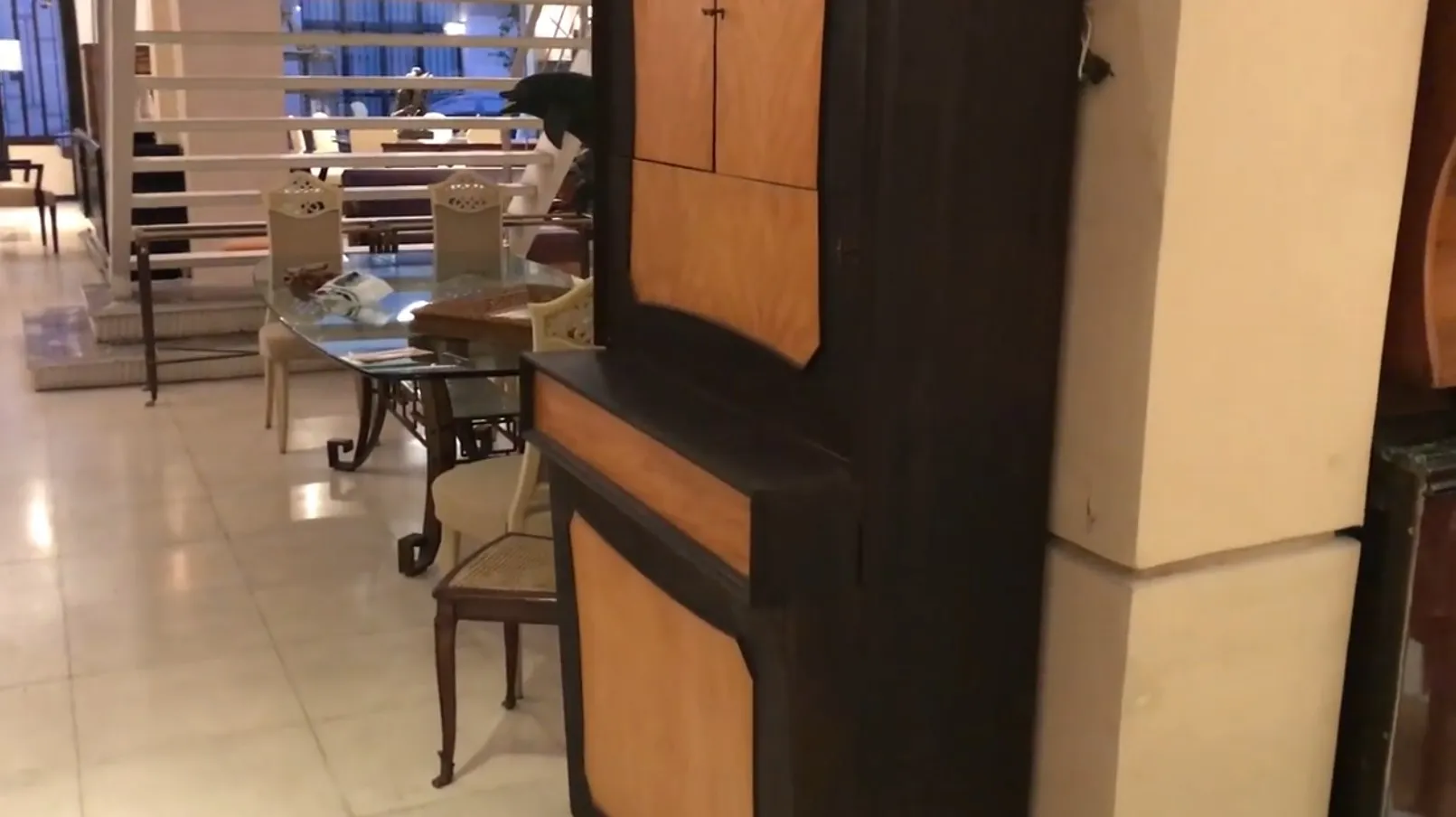 Mueble bar antiguo con puertas en color claro y oscuro, en un ambiente elegante.