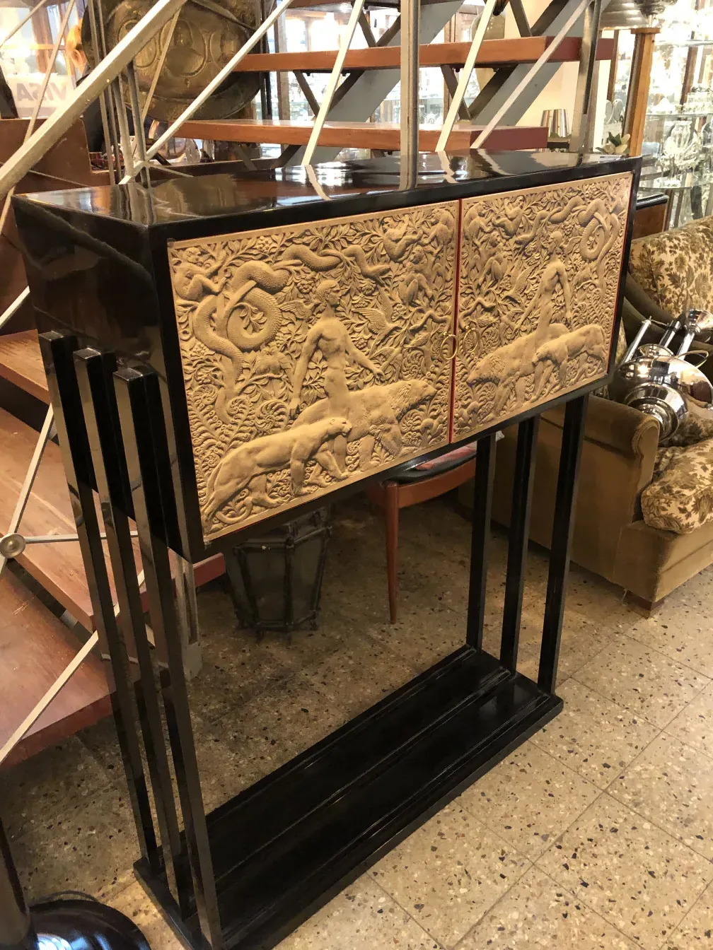 Armário de bar antigo com detalhes em relevo, fundo neutro.