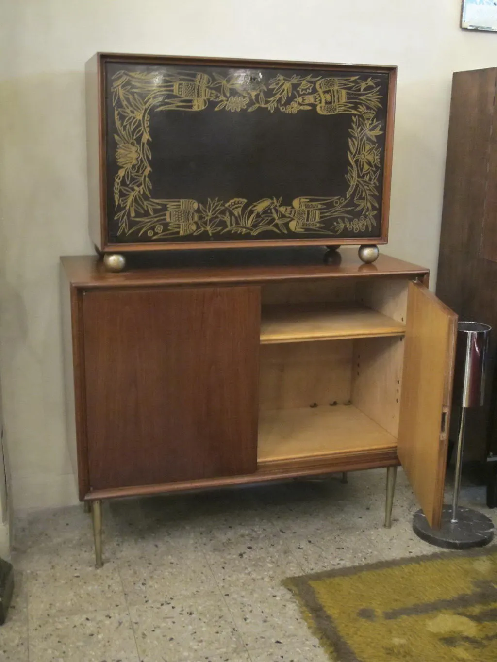 Bar aparador antigo de madeira com detalhes em dourado e design floral.