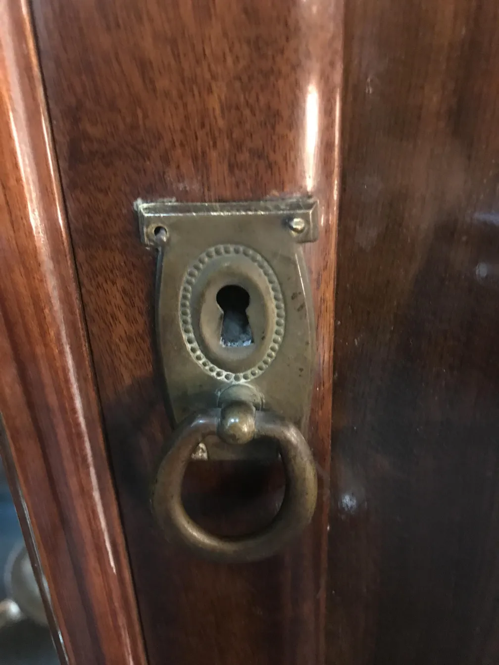 detail of an antique column with ring and decorative lock in wood