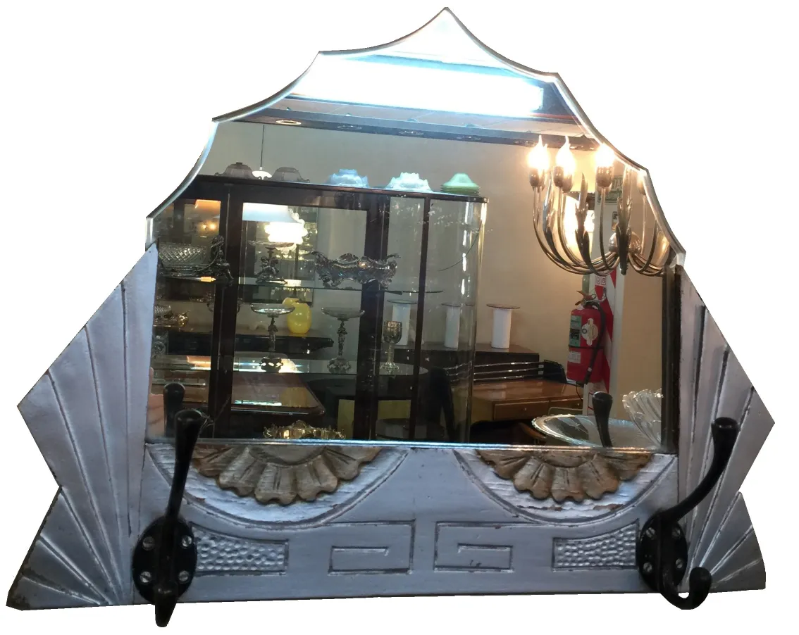 decorative antique mirror with hooks, display cabinet in background