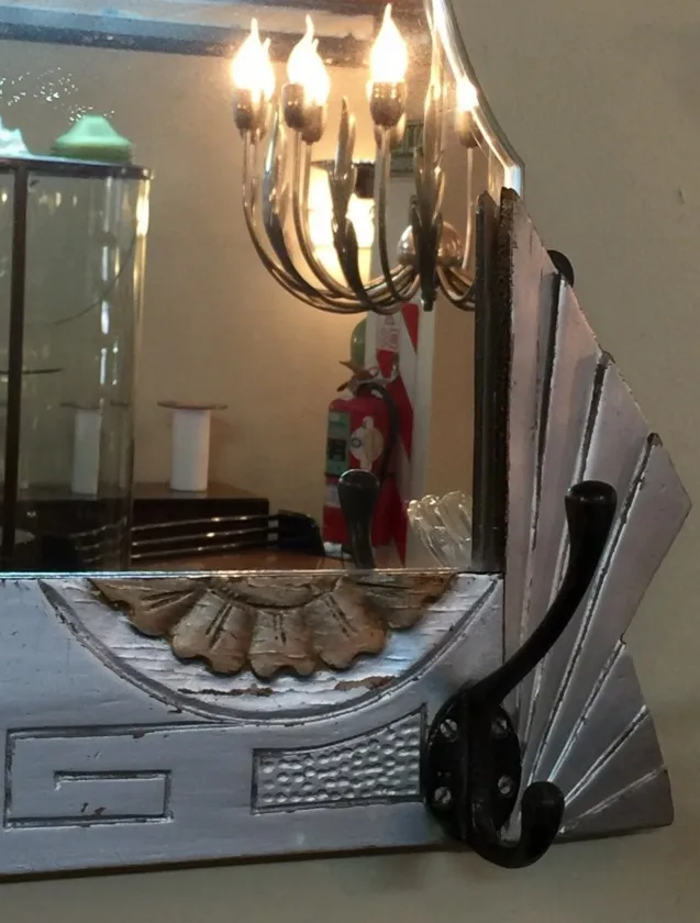 decorative antique mirror with hooks in a vintage setting