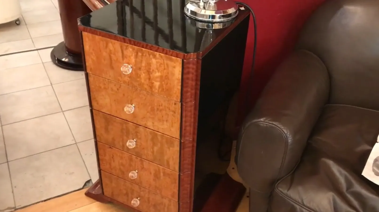 Gaveteira antiga com quatro gavetas, detalhes claros e elegante.