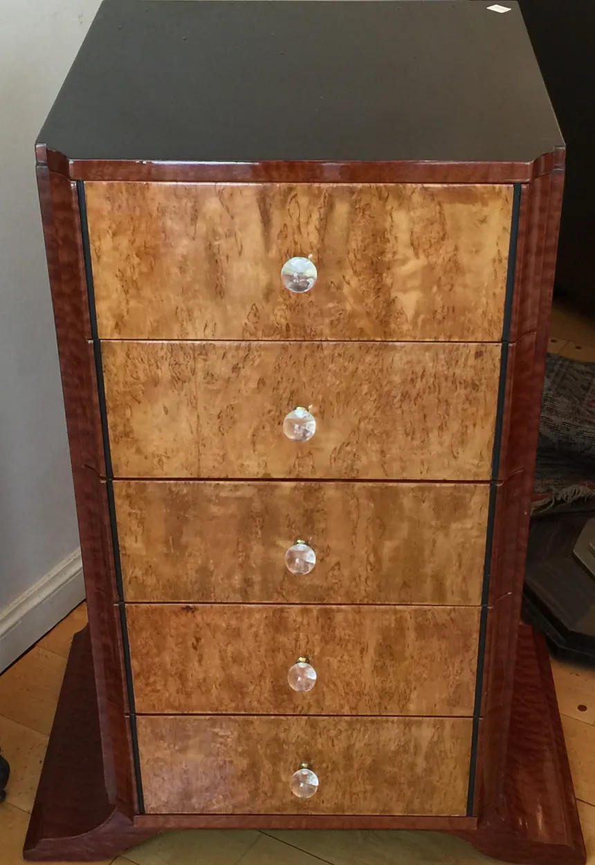 Antique cabinet with drawers and elegant handles in brown shades.