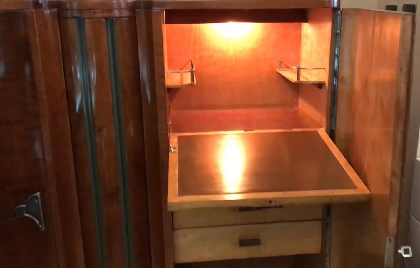 Открытый антикварный книжный шкаф с подсвеченными полками, уютная атмосфера