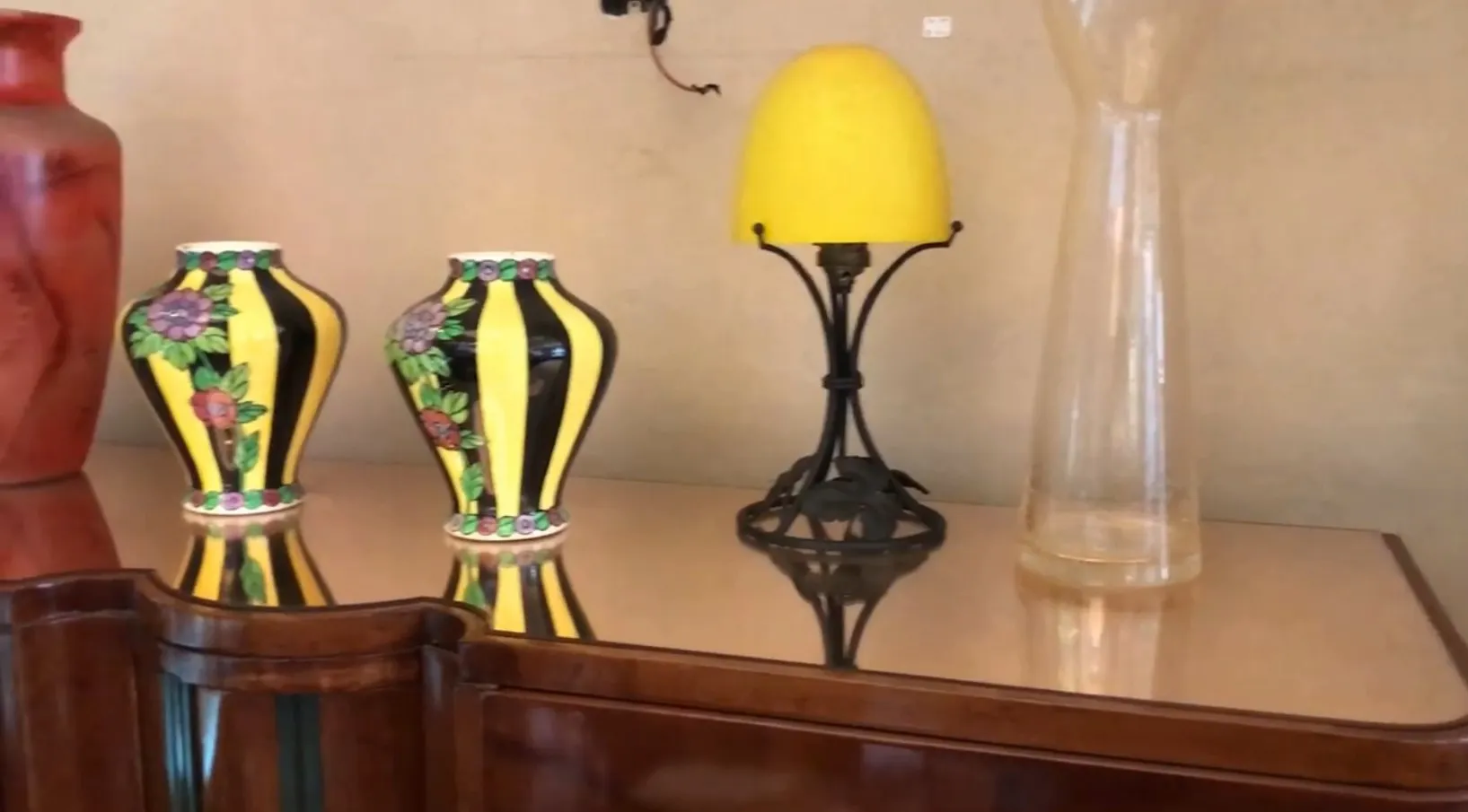 पुरानी किताबों की अलमारी के साथ सजावटी फूलदान और लैंप