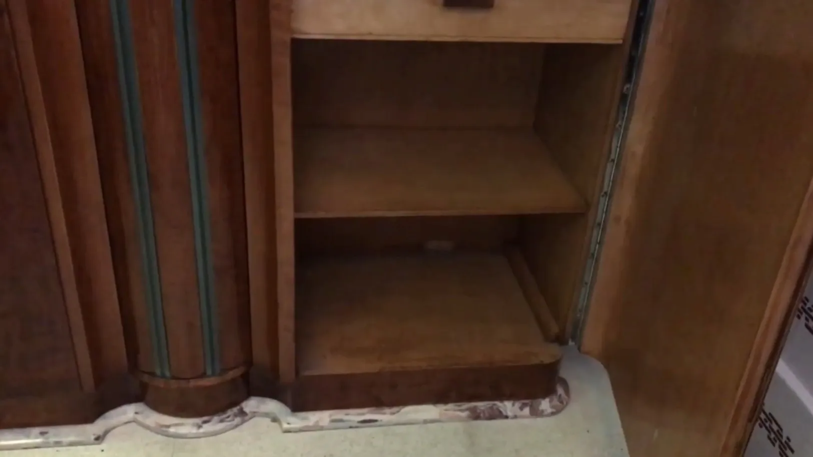 Vue intérieure d'une bibliothèque ancienne avec étagères vides et détails élégants.