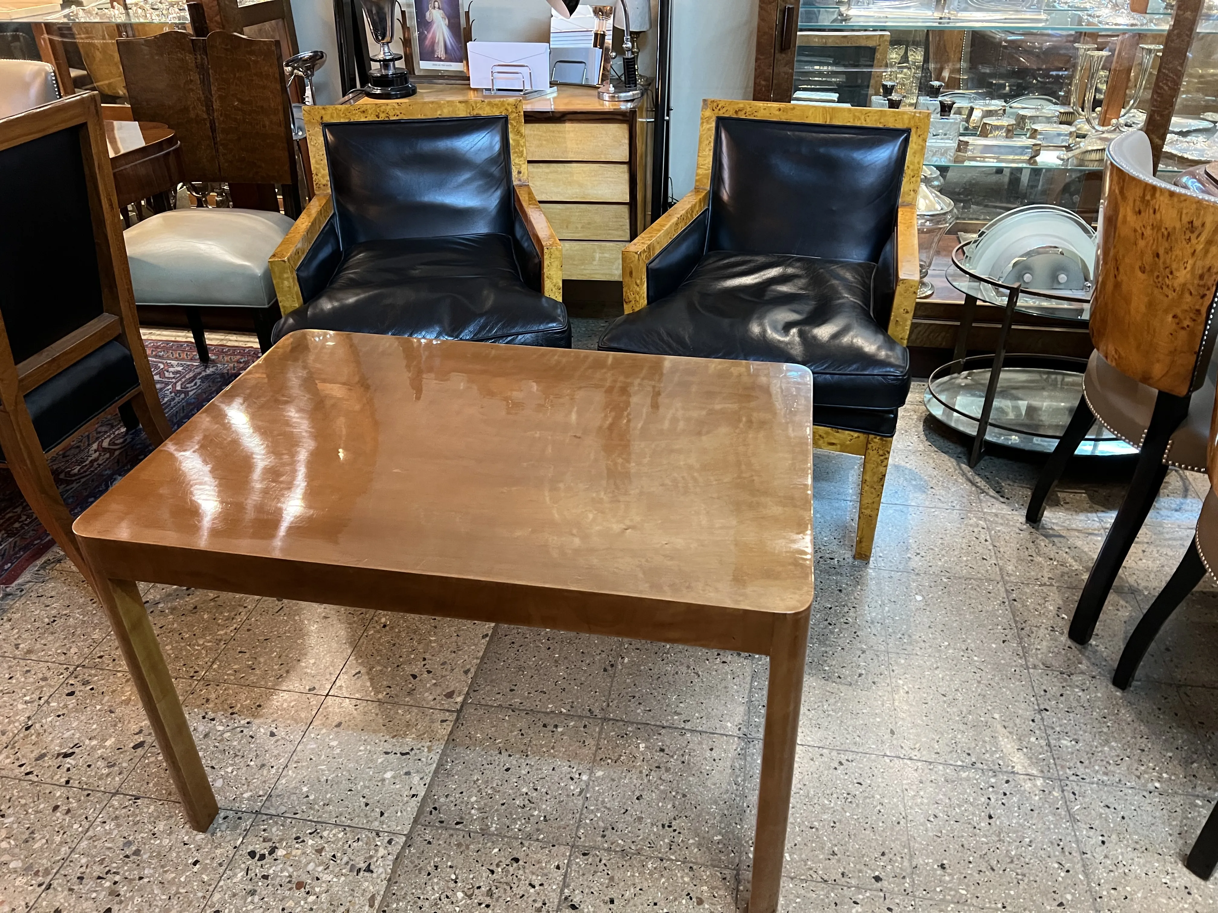 mesa ratona antigua con sillas de cuero en ambiente clásico