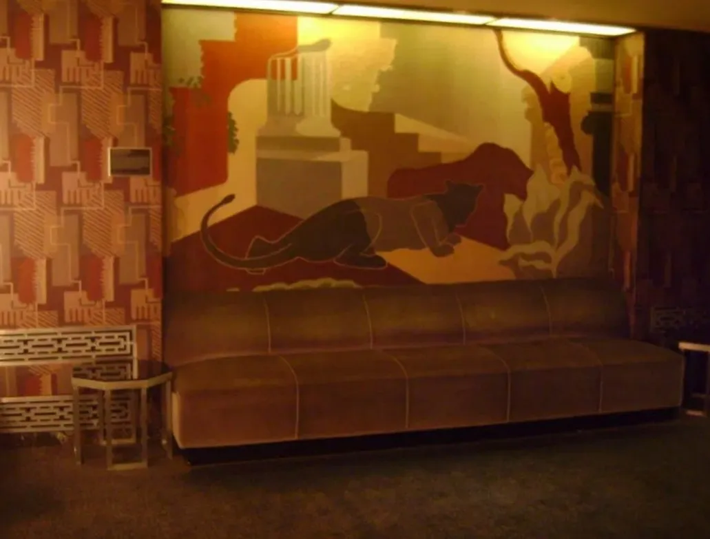 antique coffee table in a decorative setting with couch and mural