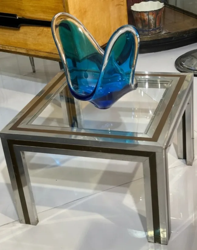 antique coffee table with shiny steel base and decorations