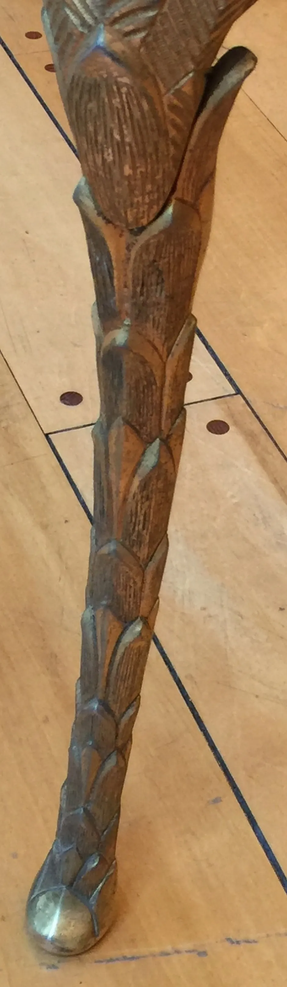 Detalle de una mesa ratona antigua con patas talladas, ambiente acogedor.