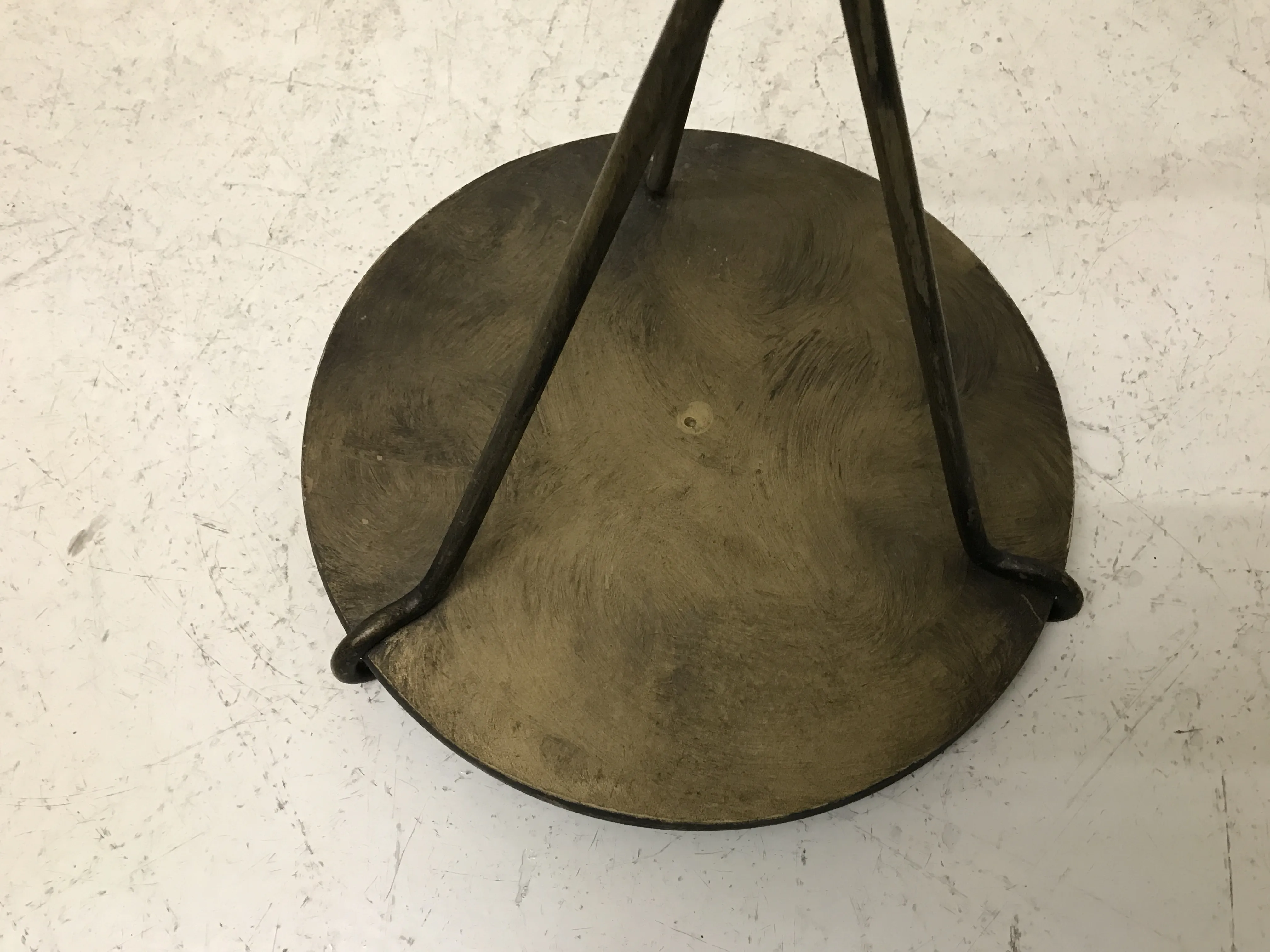 antique small table with round top and metal legs on a light background