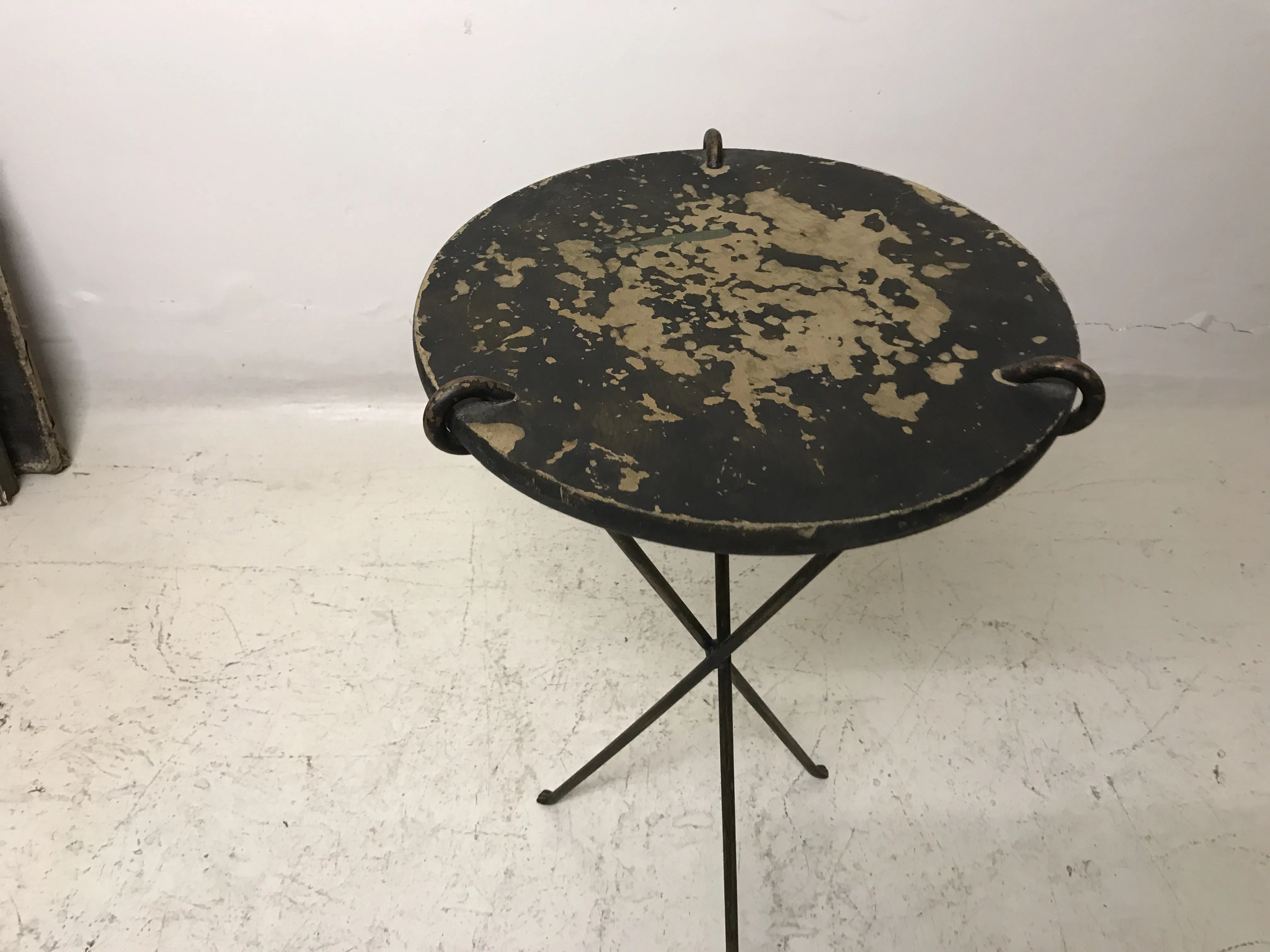 Petite table ancienne ronde avec des taches, fond clair, ambiance vintage