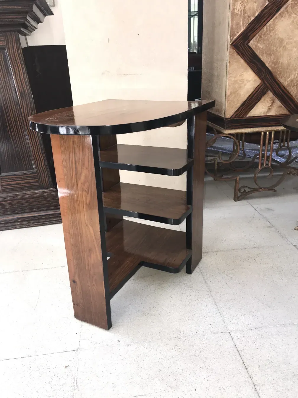 Mesa antiga de estilo Art Deco com prateleiras, decorada elegantemente.