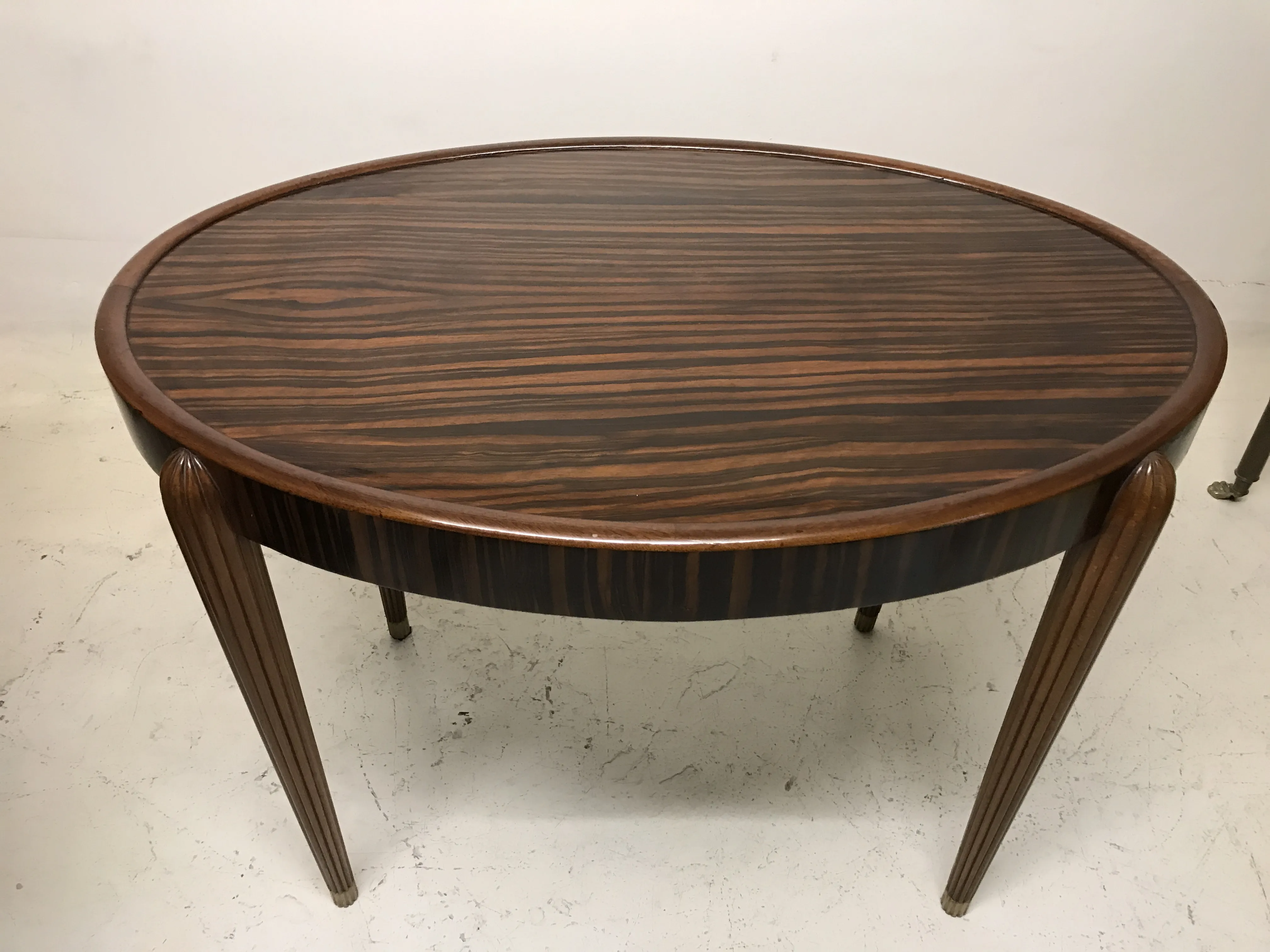 Tavolino antico rotondo con gambe eleganti, perfetto per ambienti classici.