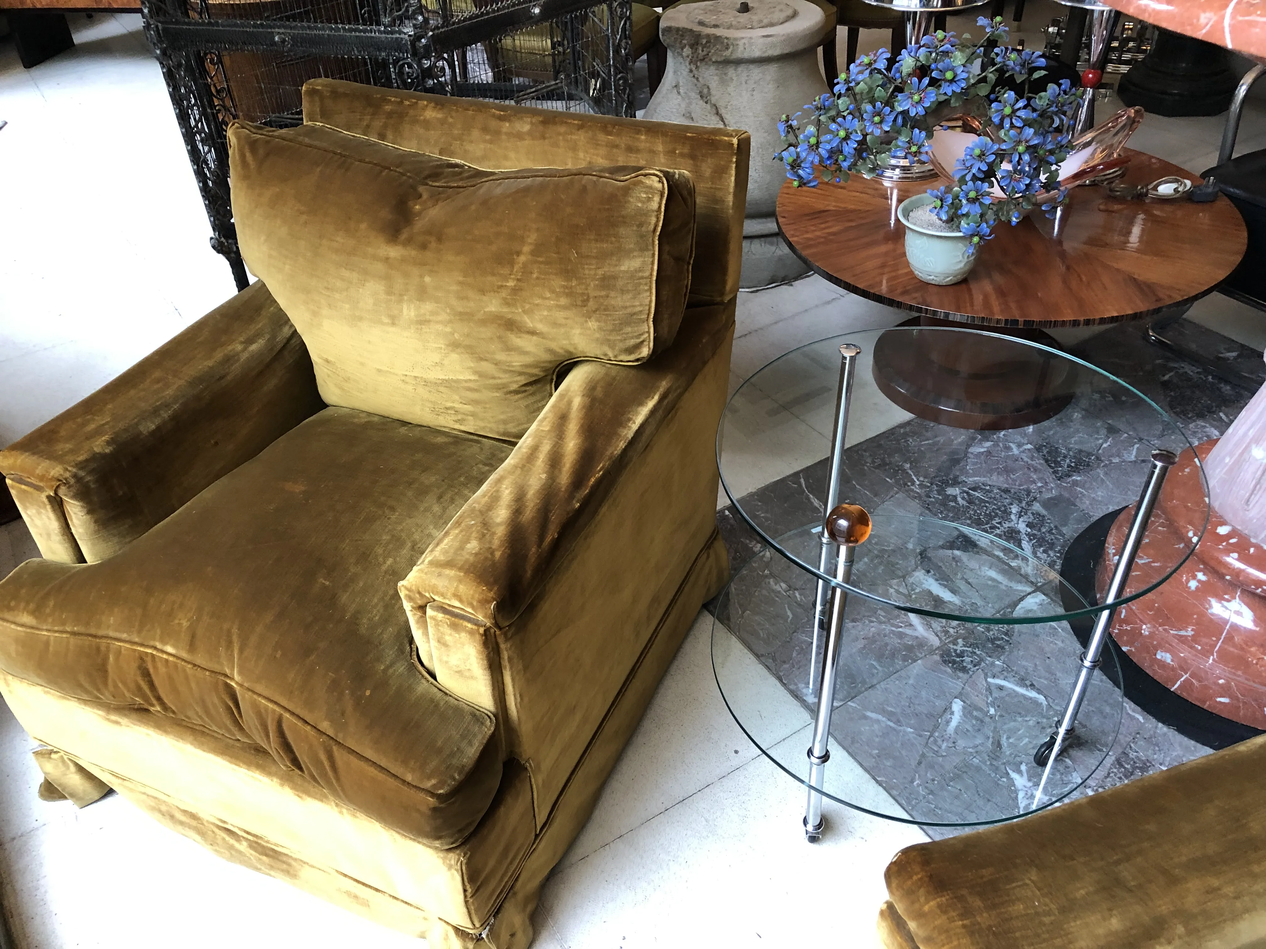 antique small table in a room with a velvet armchair