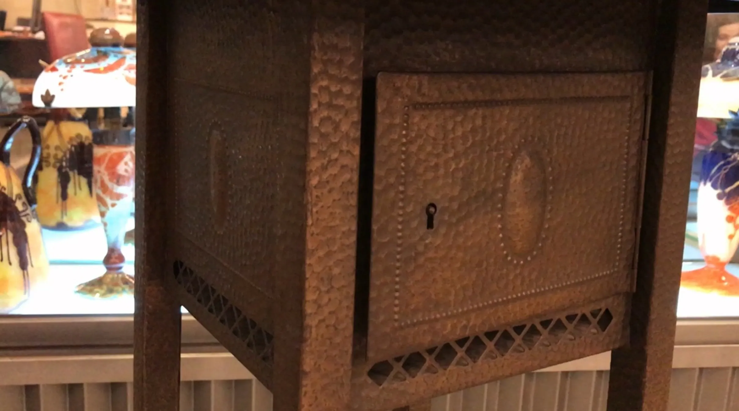 带有装饰设计和前面小抽屉的古典小桌子，周围是其他古董物品