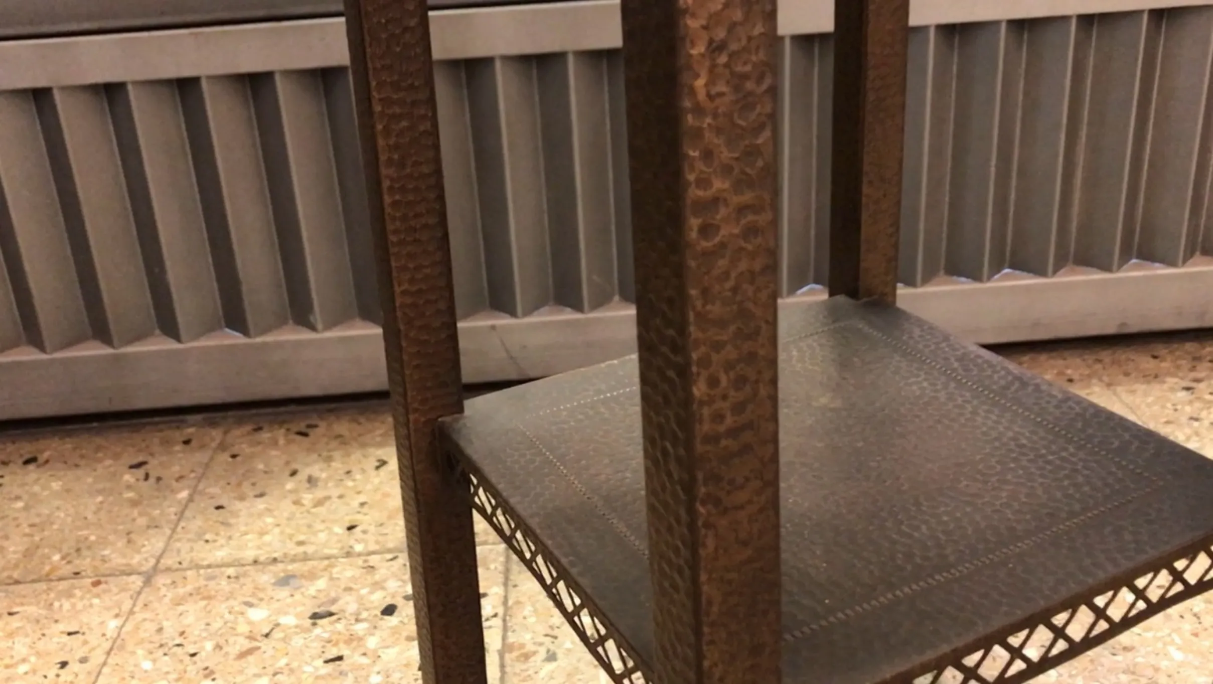 Mesita antigua baja con detalles en superficie en un entorno.