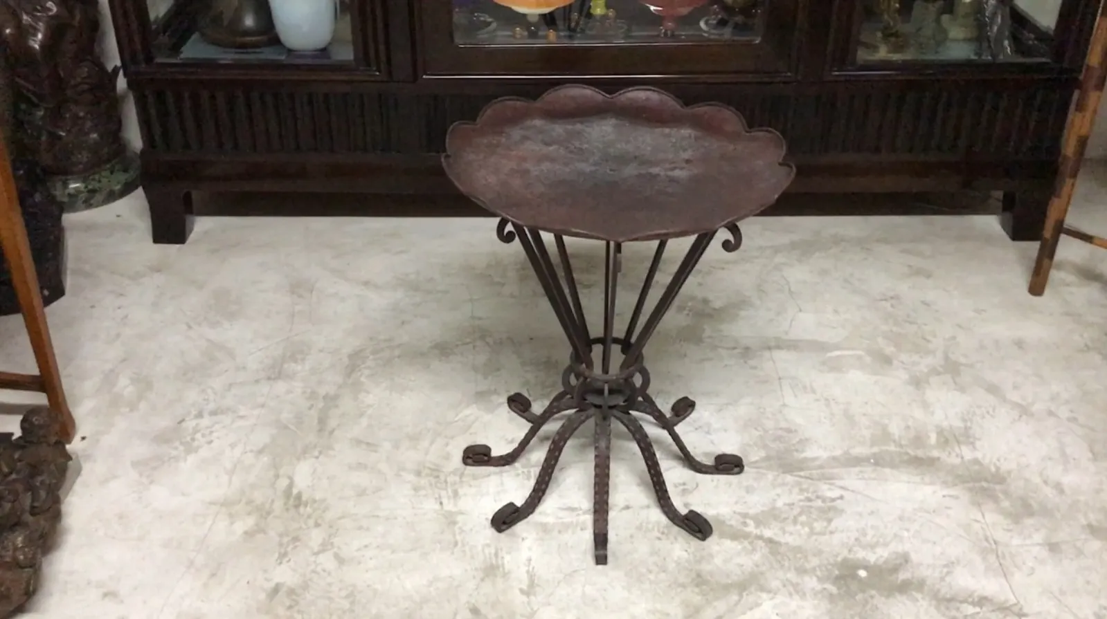 Mesa antiga art-deco com base decorativa em um ambiente aconchegante.