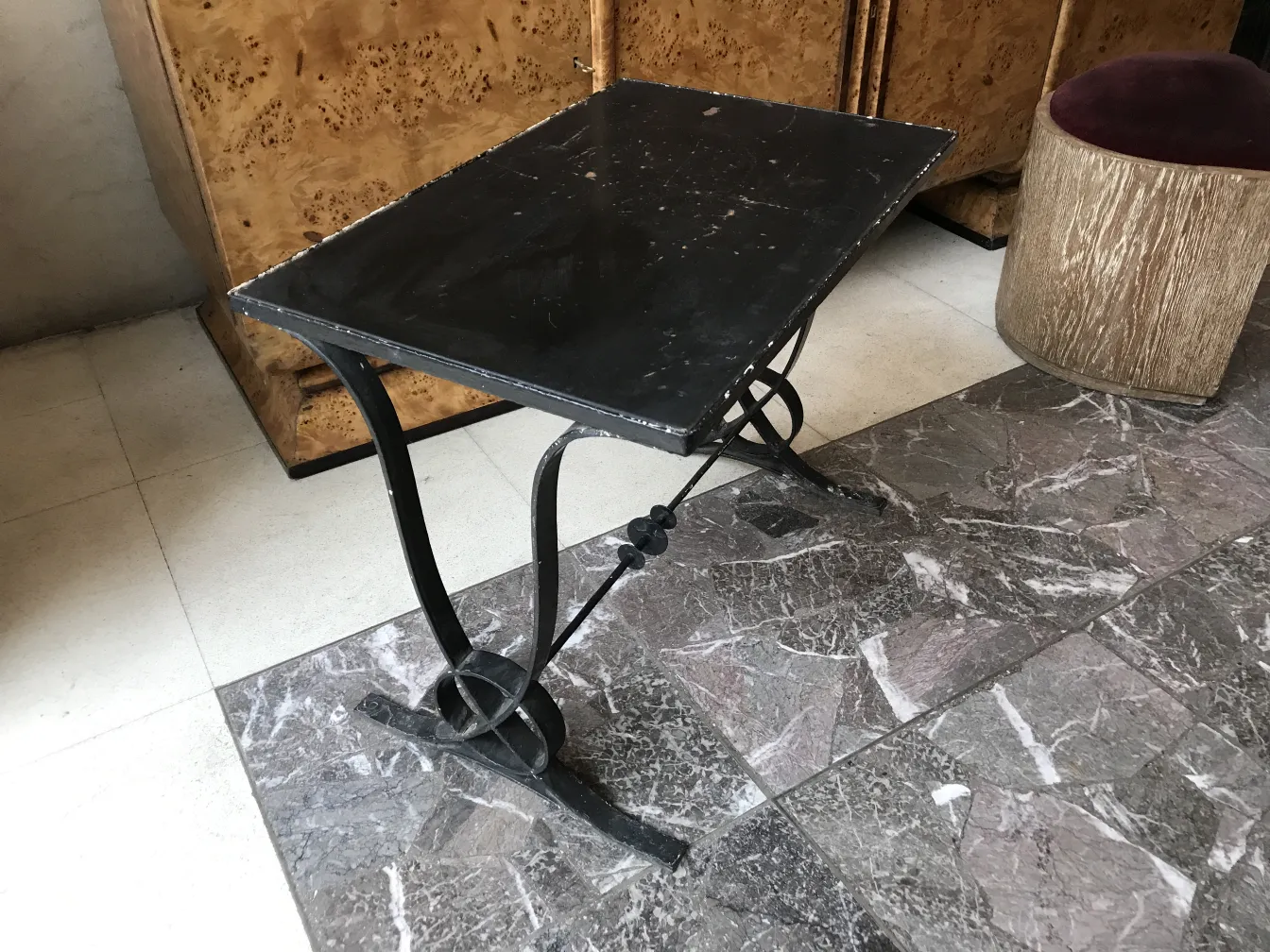 mesa antiga preta com pernas de ferro no ambiente