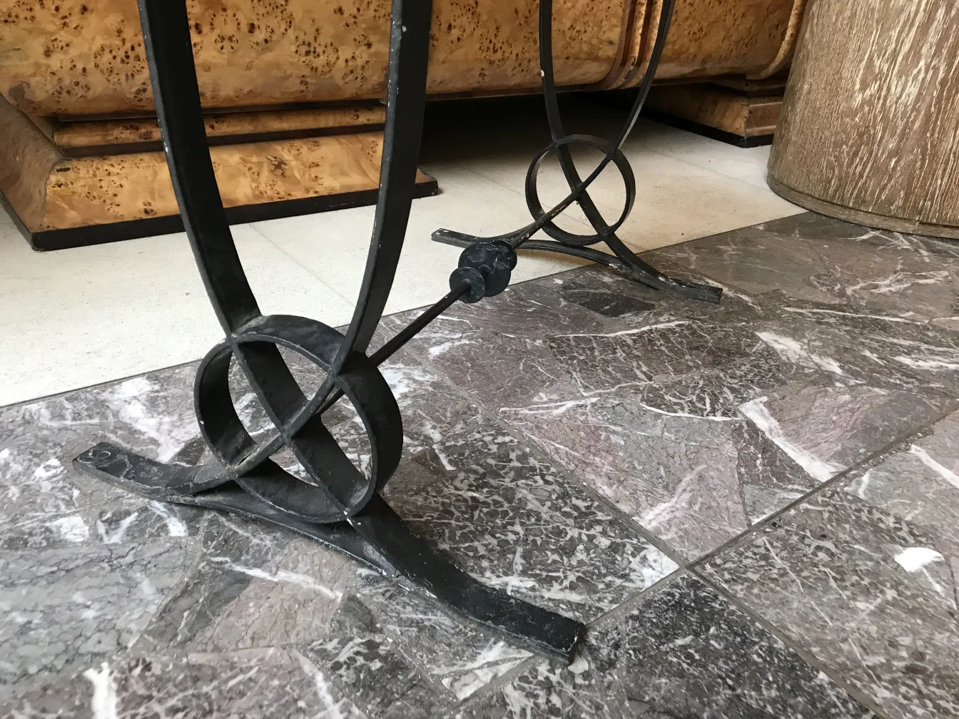 Tavolo antico con base elegante in stile art deco, circondato da un ambiente moderno.