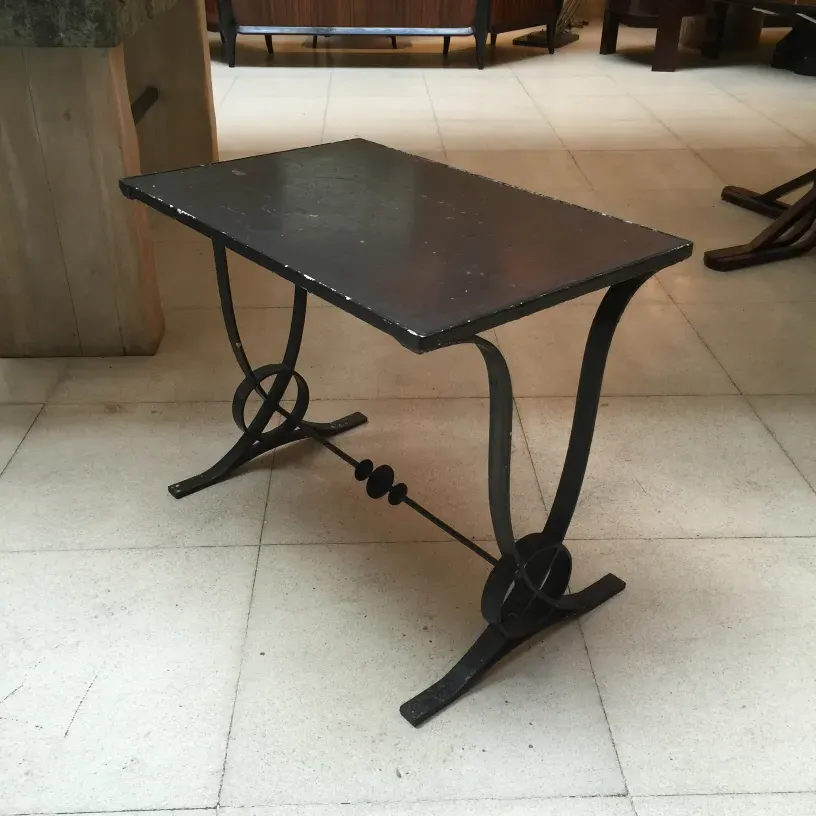 Mesa antigua de estilo Art Deco con diseño elegante y patas distintivas. Ambiente moderno.