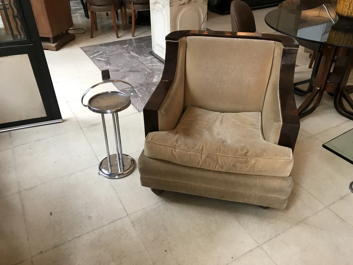 पुरानी छोटी मेज़ एक आरामदायक कुर्सी के बगल में