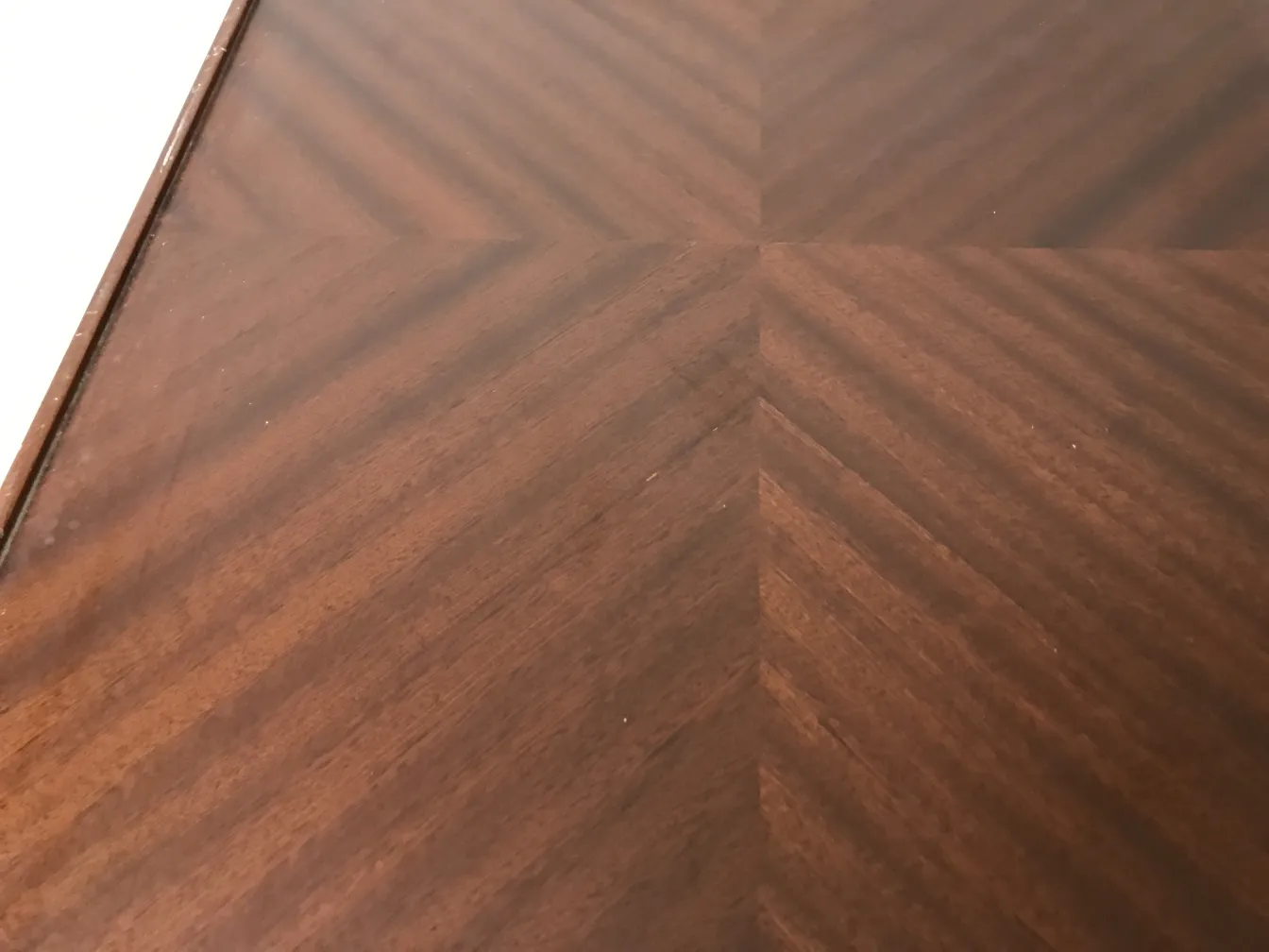 Mesa antigua de estilo Art Deco con diseño atractivo en tonos oscuros, fondo neutro.