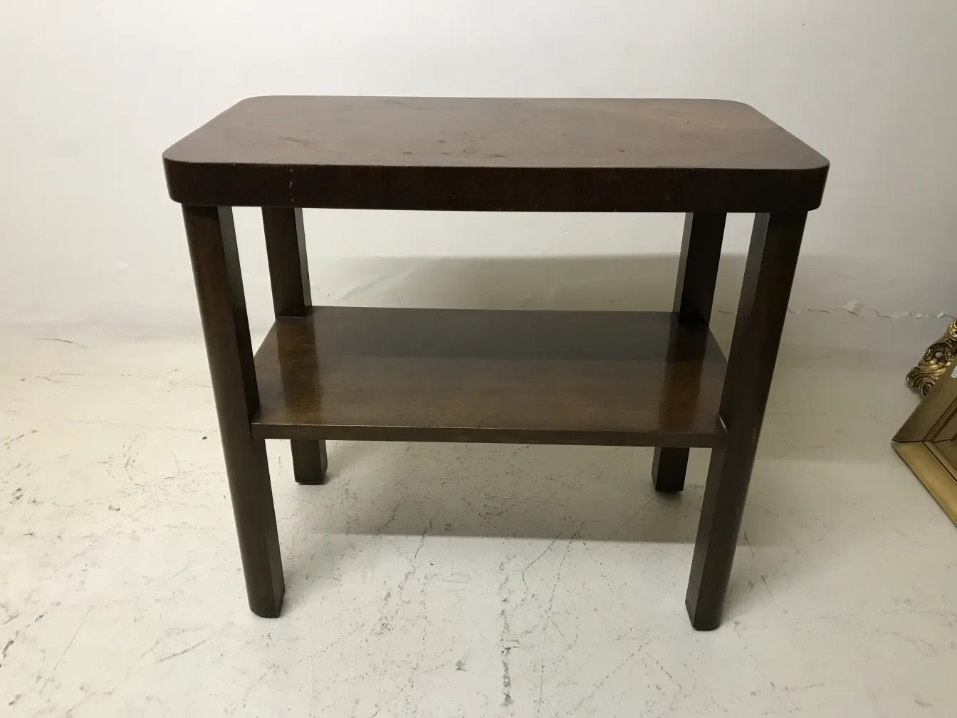 mesa antigua con un estante bajo, color marrón.