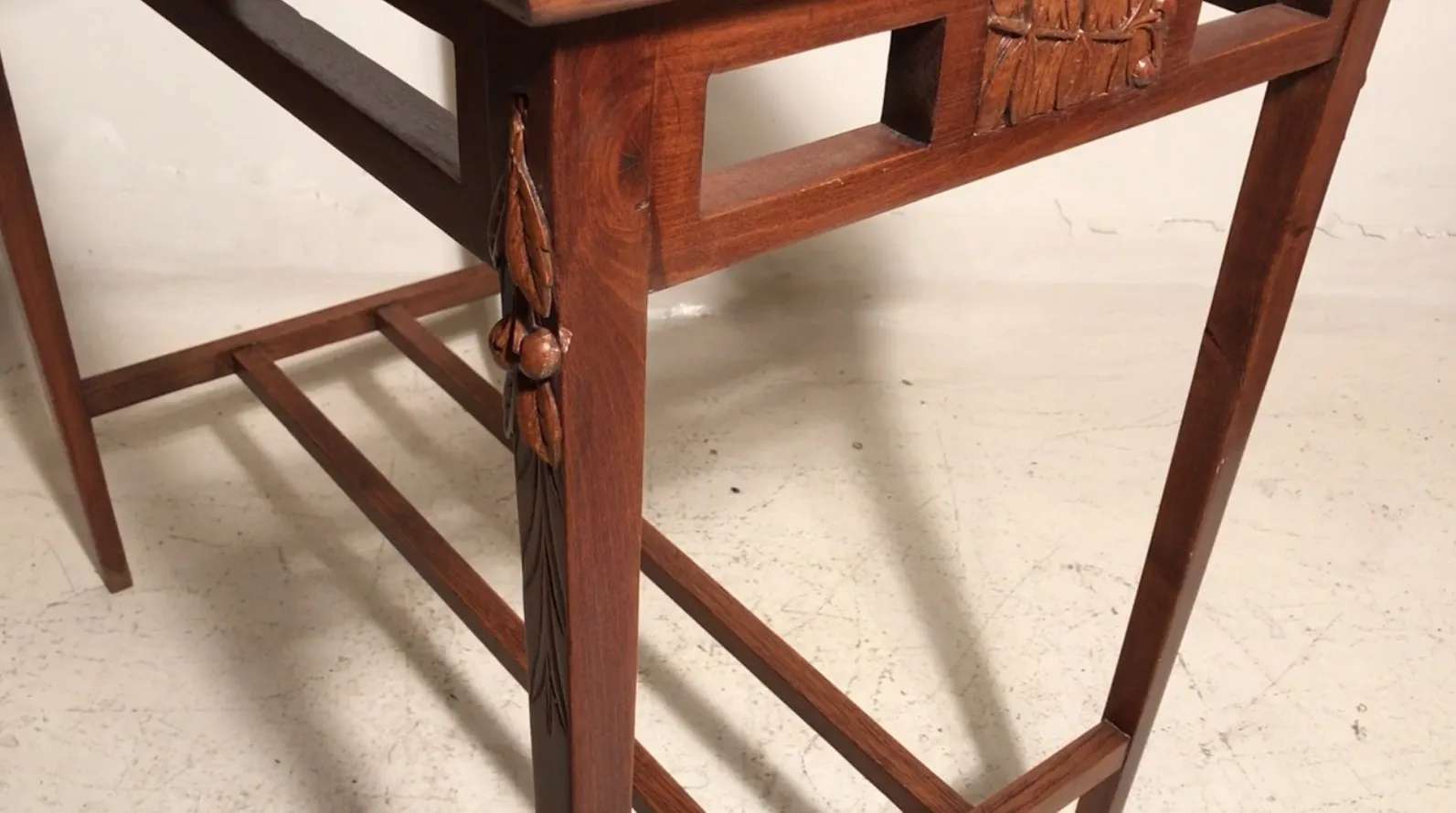 mesa antigua con tallados ornados en la parte lateral