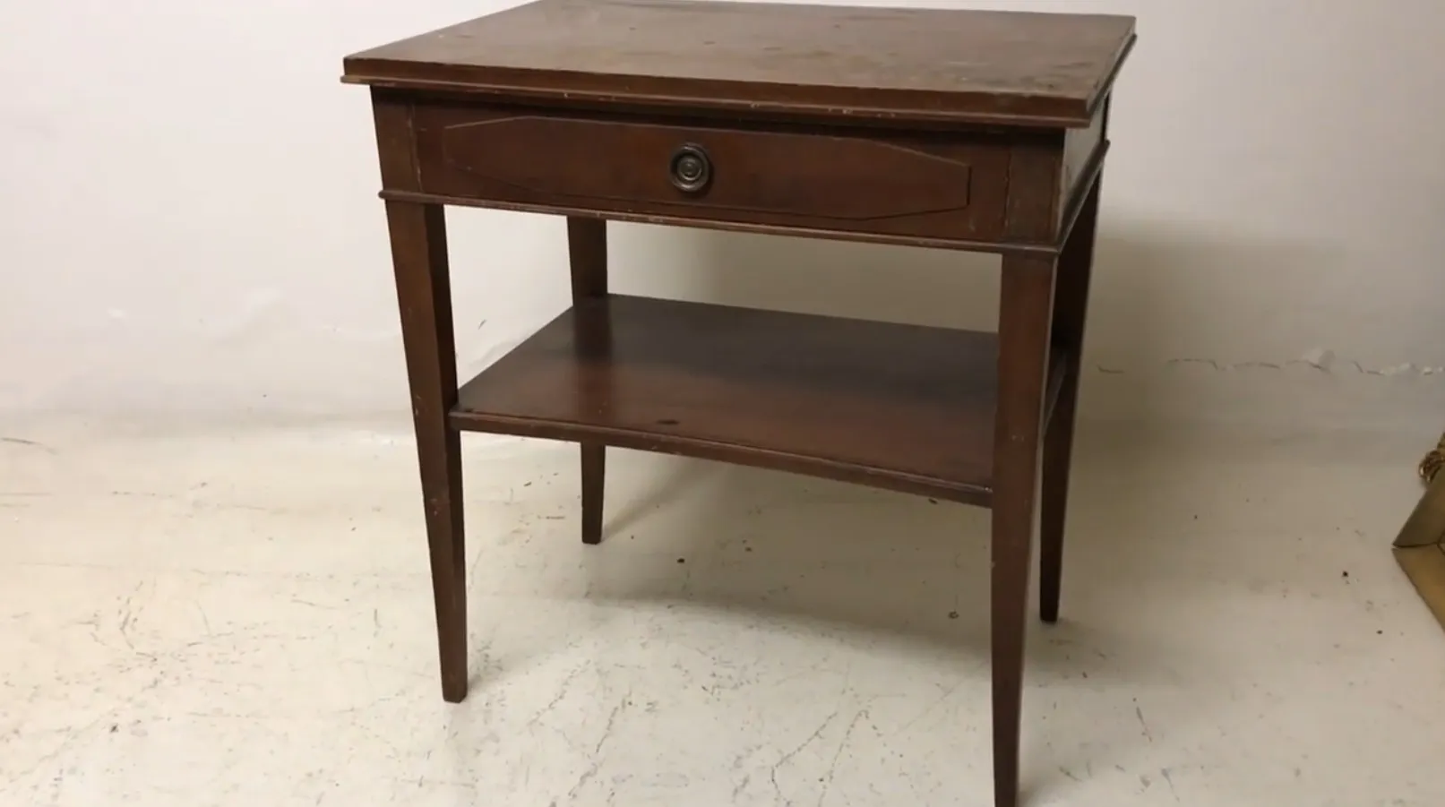 antique wooden bedside table with drawer and lower shelf in a minimalist setting