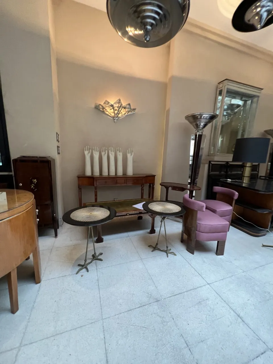 Two decorative antique small tables with elegant details, in an antique setting.