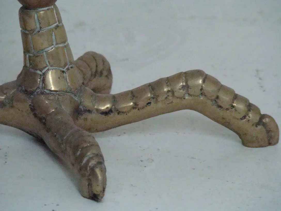 Dettagli delle gambe di 2 tavolini antichi con design intricato, in un ambiente elegante