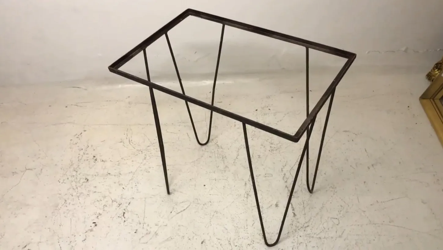 Mesa antiga com pernas finas e design simples. Ideal para jardins.