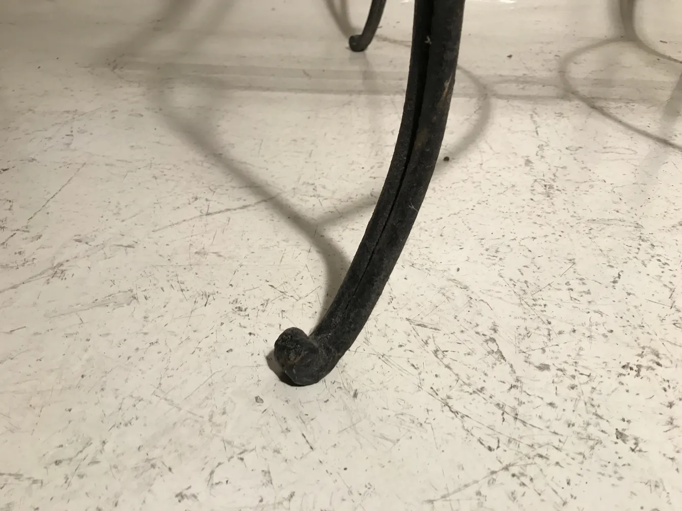 طاولة قديمة بأرجل مزخرفة في جو من الحديقة